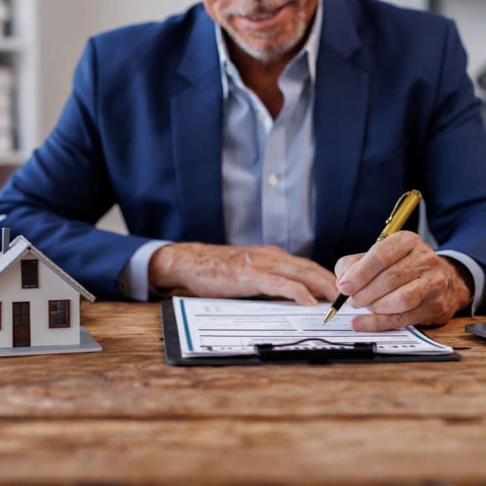 une publicité immobilière montrant un conseiller immobilier en train de signer un mandat