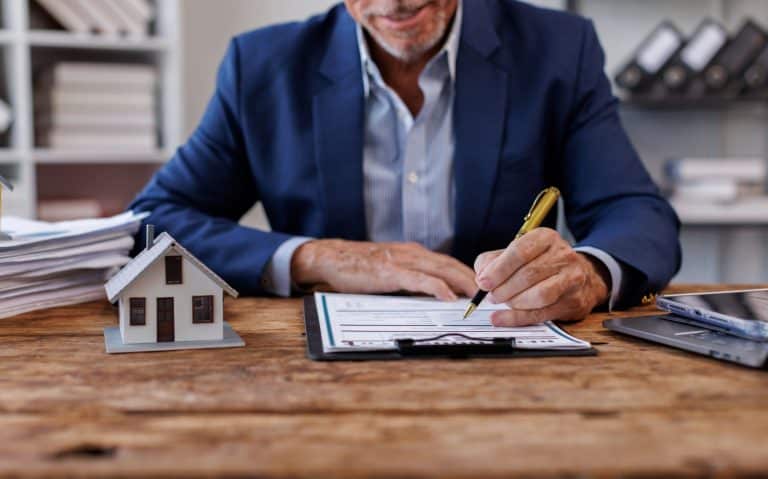 une publicité immobilière montrant un conseiller immobilier en train de signer un mandat